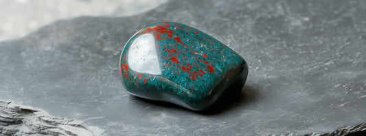 Bloodstone March birthstone with green tones and red inclusions.