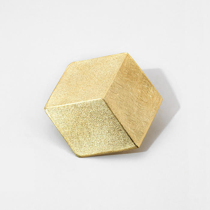 A hexagon shaped brooch reminiscent of a 3D cube, gold-plated.