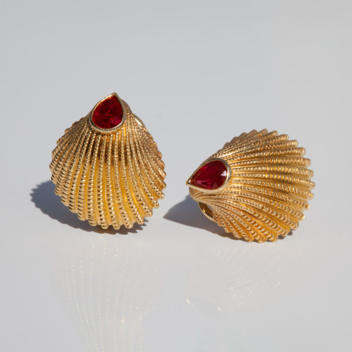 Ruby Shell Gold Earrings on a grey background 